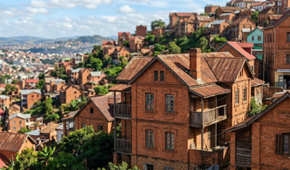 Photographie nette prise avec le zoom optique 5x du Xiaomi 15T Pro, montrant les détails architecturaux des maisons traditionnelles en briques rouges de la Haute Ville d'Antananarivo, Madagascar. L'arrière-plan de la ville est légèrement flou, soulignant la compression de perspective.